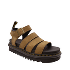 Side angle view of Savannah Tan Nubuck Blair Dr. Martens Sandal. Yellow stitching of sole, black and yellow pull tab on heel. Gold Buckle on ankle strap. Three over the top of the foot straps. Shop Womens Dr. Marten Sandals Online and in-store with shoe&me Mount Maunganui.